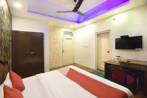 贾姆穆Super OYO Hotel Maa Residency的一间卧室配有一张带吊扇的床和一张书桌。
