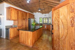 罗阿坦Apricari House Stunning Views 3 BDRM and Pool的厨房配有木制橱柜和黑色台面