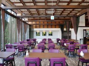 Ōmuta新加雅奥姆塔花园酒店的一间用餐室,配有紫色的椅子和桌子
