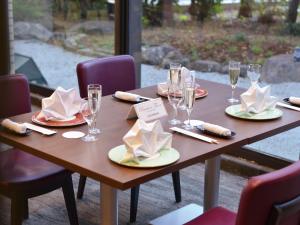 Ōmuta新加雅奥姆塔花园酒店的木桌,带盘子、酒杯和餐巾