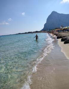 圣维托罗卡波L'Isola nel Mare的站在海滩水面上的男人