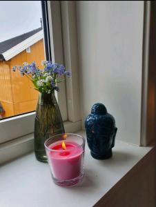 利勒哈默尔Fantastic and high standard apartment in Nordseter的窗台上的蜡烛和花瓶