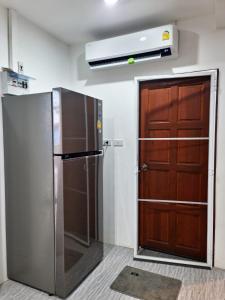 Ban Saiyuan (1)Phujhaofa villa club ( ไสยวน)的带冰箱和木门的厨房