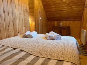 SicasăuAproka - Chalet Mignon Adorable small guest house的一间卧室配有带毛巾的床