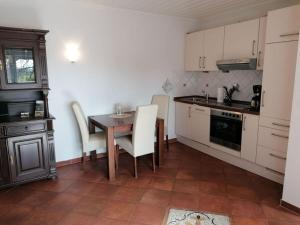 诺德代希Deichjuwel Comfortable holiday residence的厨房配有桌子、白色橱柜和桌椅