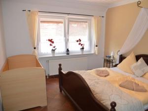 诺德代希Deichjuwel Comfortable holiday residence的一间卧室设有一张床和一个鲜花窗口