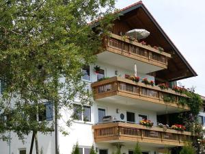 韦尔塔赫Alpine Lodge Comfortable holiday residence的一座带木阳台和鲜花的建筑