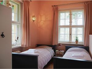 Villa Sommerfeld的一间卧室设有两张床和两个窗户。