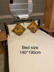安塔利亚M-ODA OTEL的一张带两个黄色枕头和镜子的床