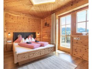 希帕赫Wellness Chalet Bergschlössl的木制客房内的一间卧室,配有一张床