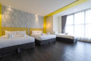 台中市凝萃文旅台中車站店 NCH - NingCui Business Hotel的黄色墙壁客房的两张床