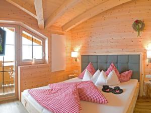 希帕赫Romantic Chalet Waldschlössl的一间卧室配有红色和白色枕头的床