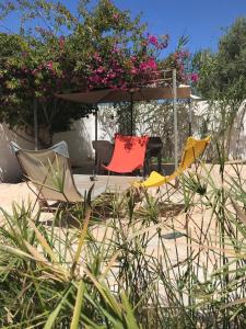 米多恩Suite indépendante Chez l'Artiste的沙子里的一组椅子和一把雨伞