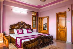 西姆拉Goroomgo शिमला Nature Ville - A Luxury Collection的一间卧室配有一张带粉红色墙壁的木床