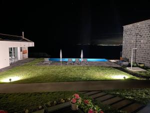 Santo AntónioJoão de Oliveira - casas de campo的一个带椅子的院子和夜间游泳池