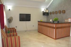 库马西Gold Plus Hotel Ghana的一间墙上配有平面电视的等候室
