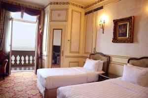 亚历山大Windsor Palace Luxury Heritage Hotel Since 1906 by Paradise Inn Group的酒店客房设有两张床和窗户。