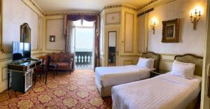 亚历山大Windsor Palace Luxury Heritage Hotel Since 1906 by Paradise Inn Group的酒店客房设有两张床和电视。