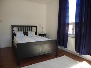 菲斯卡斯Lindallén Guest House的一间卧室配有一张带蓝色窗帘的床和一扇窗户