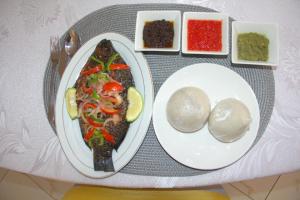 库马西Gold Plus Hotel Ghana的桌上一盘食物,上面有一盘食物