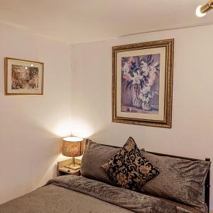 AddingtonPrivate apartment in a big bungalow in Selsdon!的卧室配有一张床,墙上挂有绘画作品