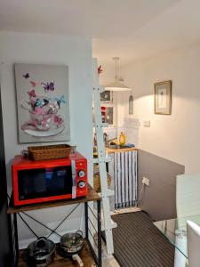 AddingtonPrivate apartment in a big bungalow in Selsdon!的厨房里一张桌子上的一个红色微波炉