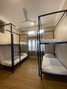 古瓦哈提Hostello Backpackers Hostel的客房设有三张双层床和天花板。