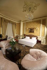 亚历山大Windsor Palace Luxury Heritage Hotel Since 1906 by Paradise Inn Group的一间卧室配有一张床、两把椅子和一张桌子