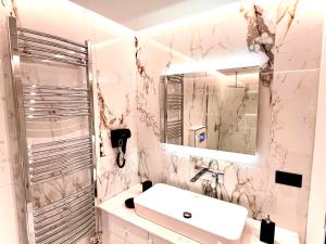 卡萨米尔ILLYRIAN hotel的白色的浴室设有水槽和镜子