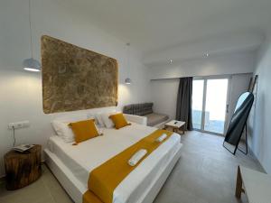 法里拉基Ladiko Inn Hotel Faliraki -Anthony Quinn Bay的一间卧室配有一张大床和一张沙发