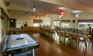 MarchulaTashree Kabeela Riverside Resort的餐厅设有酒吧,配有桌椅