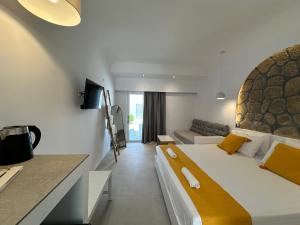 法里拉基Ladiko Inn Hotel Faliraki -Anthony Quinn Bay的一间卧室配有一张大床和一张沙发