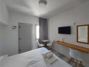 纳克索乔拉Castellino Naxos的一间卧室配有一张床、一张书桌和一面镜子