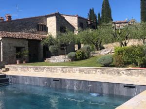 拉达-因基安蒂Casa Colle Petroso的房屋前的大型游泳池