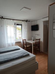 托尔明Sobe Černilogar的一间卧室配有一张床和一张桌子及椅子
