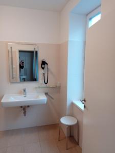 萨尔茨堡阿德霍夫酒店的一间带水槽的浴室和墙上的一部电话