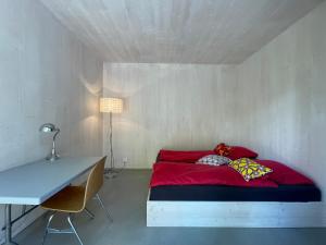 格里翁Chalet contemporain的一间卧室配有红色的床和一张书桌
