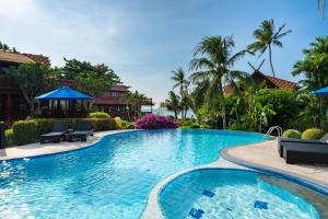 班邦宝Beachfront Villa, Bang Po的一个带椅子和遮阳伞的度假村游泳池