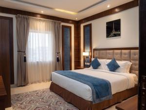 利雅德Innyar Hotel - فندق انيار的一间卧室设有一张大床和一个窗户。