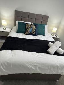 布伦特伍德Spacious, bright, modern flat的一间卧室配有一张带绿色和白色枕头的大床