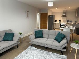 布伦特伍德Spacious, bright, modern flat的一间带两张沙发的客厅和一间厨房