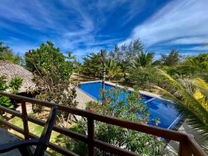 阿鲁甘湾Whisky Point Surf Cabana的设有一个游泳池的度假村阳台,享有风景