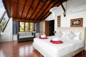班邦宝Beachfront Villa, Bang Po的卧室配有一张白色大床和一把椅子