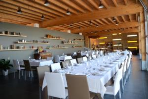 卡斯特拉巴特滨海Tocchi di Puglia的一间长餐厅,配有白色的桌子和椅子