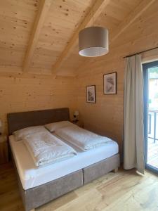 黑马戈尔Wohlfühlchalet Hermagor-Nassfeld-Weissensee的木制客房内的一间卧室,配有一张床