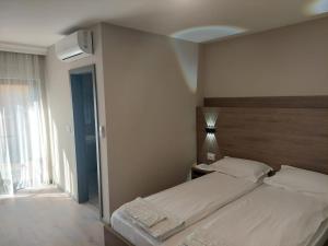 蒂米什瓦拉Pensiunea Normandia的一间卧室配有一张带床头板的床和窗户