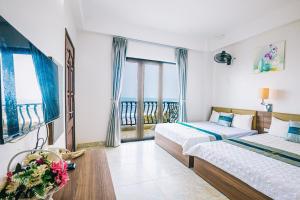 岑山Hương Lý Hotel的酒店客房设有两张床和一个阳台。
