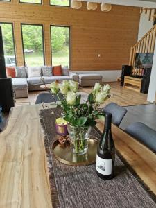 IzvoareA Sziget的一瓶葡萄酒和一瓶花在桌子上