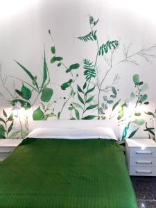 博洛尼亚Dimora Sterlizia zona Fiera S Donato的卧室配有一张挂在墙上的绿色植物床。