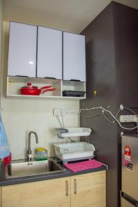 莎阿南Homestay at Menara U的厨房配有水槽和白色橱柜